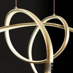 3D model of the lampatron NORVIN B LUX gold pendant lamp, featuring two intersecting, abstractly curved golden metal strips with integrated LED light channels.
