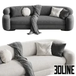 3D model of the Zae Sofa featuring a modern organic kidney-bean shape, upholstered in textured white and grey bouclé fabric, styled with round cushions and a draped throw blanket.